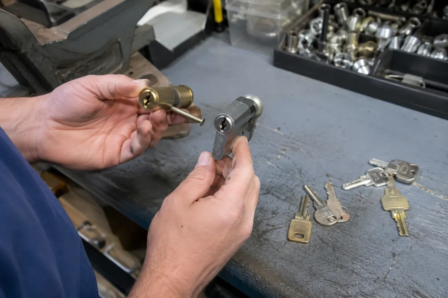 Hands comparing detached lock cylinders beside loose keys on a workbench. — Broken Key Extraction, Caledon